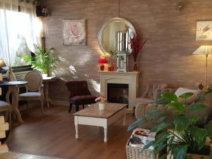 a living room with a fireplace and a mirror at Contact Hôtel Come Inn in Poitiers