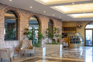 a lobby with chairs and a brick wall at Aktug Elegance Hotel in Ordu