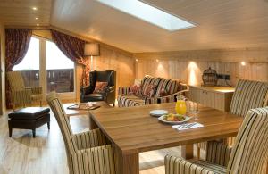 a dining room with a wooden table and chairs at Le Calgary in Les Saisies