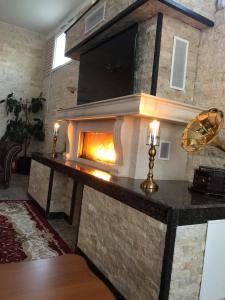 a stone fireplace in a living room with a tv at Hotel Restaurant Elite in Drobeta-Turnu Severin