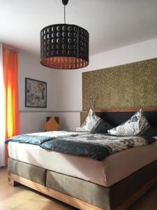 a bedroom with a large bed and a chandelier at Gaestehaus Klaus in Mendig