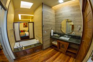 a bathroom with a tub and a sink and a mirror at Baldi Hot Springs Hotel & Spa in Fortuna