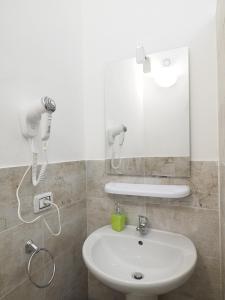 ein Badezimmer mit einem weißen Waschbecken und einem Spiegel in der Unterkunft b&b del corso in Iglesias