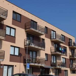 ein Apartmenthaus mit Balkonen und Autos, die vor dem Haus geparkt sind in der Unterkunft HOME 223 - designový apartmán in Jihlava