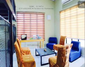 a room with chairs and a table and a desk at Homestay Terengganu Faidaville in Kuala Terengganu