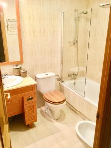 a bathroom with a toilet and a sink and a shower at Moderno,luminoso con plaza de garaje in Madrid