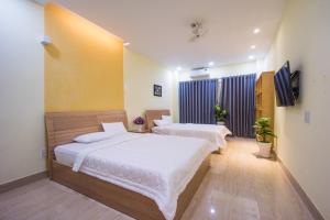 a bedroom with two beds and a flat screen tv at Language Exchange Hostel 1 in Ho Chi Minh City