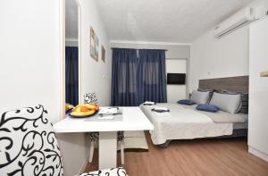 una camera con letto e tavolo di Apartments Song of Joys a Makarska