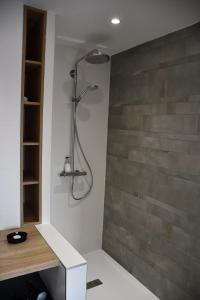 um chuveiro na casa de banho com uma parede de tijolos em L'appart' em Schwenheim