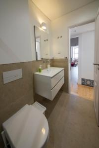 La salle de bains est pourvue d'un lavabo blanc et de toilettes. dans l'établissement Luxurious Cais do Sodre - 4 bedrooms with amazing view, à Lisbonne
