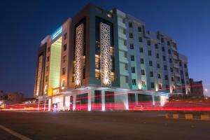 un gran edificio con luces frente a una calle en Hafawah Suites en Medina