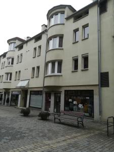 a bench sitting in front of a building at Teleki Apartman Kaposvár in Kaposvár