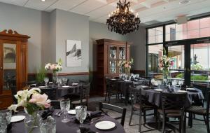 a dining room with tables and chairs and a chandelier at Hotel Anthracite in Carbondale +28 photos
