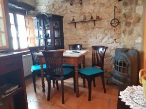 a dining room with a table and chairs and a stove at Casa Encarnacion in Santo Emiliano