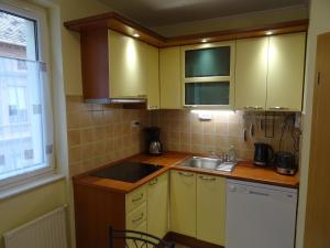 a kitchen with yellow cabinets and a sink and a window at Teleki Apartman Kaposvár in Kaposvár +16 photos