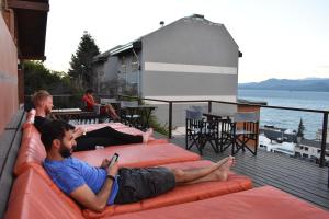 
a man laying on top of a red couch at Hostel Inn Bariloche in San Carlos de Bariloche
