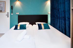 - 2 lits jumeaux dans une chambre aux murs verts dans l'établissement Résidence AURMAT - Appart - Hôtel - Boulogne - Paris, à Boulogne-Billancourt