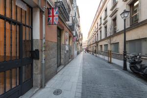 馬德里的住宿－Wonderful Apartment Chueca，一座空荡荡荡的街道,在建筑物上悬挂着一幅英国国旗