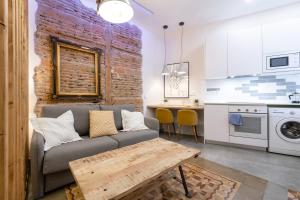 a living room with a couch and a brick wall at Wonderful Apartment Chueca in Madrid