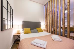 a bedroom with a bed with yellow and gray pillows at Wonderful Apartment Chueca in Madrid