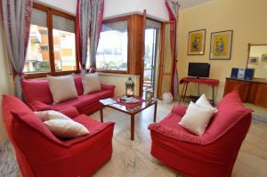 a living room with red chairs and a table at Carnevale in Viareggio