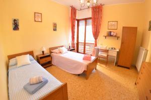 a bedroom with two beds and a desk and a window at Carnevale in Viareggio