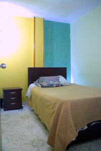 a bedroom with a bed and a dresser in it at Hostel Casa Alb in Bogotá