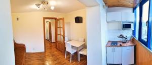 a kitchen with white cabinets and a table and a chair at Nice apartment on street Alexandru cel bun 108 in Chişinău