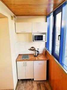 a small kitchen with white cabinets and a microwave at Nice apartment on street Alexandru cel bun 108 in Chişinău