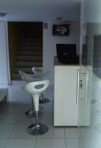 una cocina con 2 taburetes y un mostrador con ordenador en Pousada NS Fátima, en Fortaleza