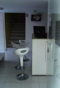 a kitchen with two stools and a counter with a computer at Pousada NS Fátima in Fortaleza