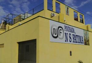 a yellow building with a sign on the side of it at Pousada NS Fátima in Fortaleza