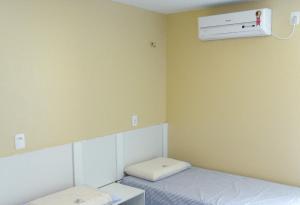 a small room with a bed and a air conditioner on the wall at Pousada NS Fátima in Fortaleza