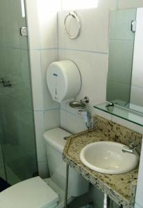 y baño con lavabo, aseo y espejo. en Pousada NS Fátima, en Fortaleza