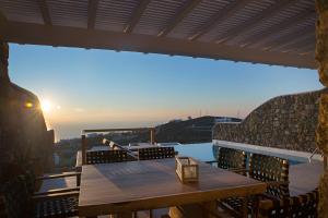 a table on a balcony with a view of the city at VILLA APOLLO-PRIVATE POOL-AMAZING VIEW in Mýkonos City