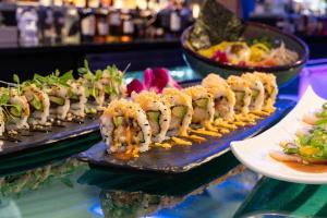 a buffet of food on a table with sushi at Naples Grande Beach Resort in Naples