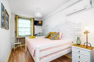 une chambre avec un lit blanc et une fenêtre dans l'établissement Casa Sá Noronha Old Town, à Porto