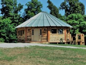 a small wooden building with a tin roof at The Highlander - Rustic Mountain Yurt in Genoa