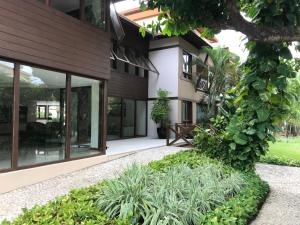 a house with large windows and plants at Porto Praia do Forte in Praia do Forte