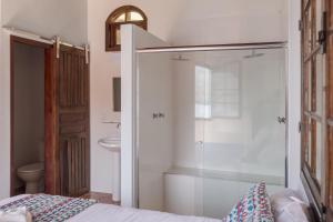 a bathroom with a shower and a toilet and a bed at Pousada Toca do Mar in Praia de Palmas