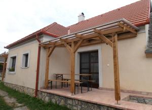 een houten paviljoen met een picknicktafel op een huis bij Sváb Ház in Veszprémfajsz