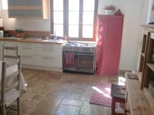 ユゼスにあるmaison du figuierのキッチン(コンロ、赤い冷蔵庫付)