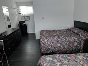 a hotel room with a bed and a dresser at Hilltop Motel in Kingston