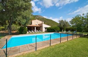 a fence around a swimming pool in a yard at Can Pontico in Pollença