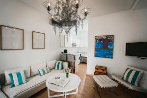 a living room with a couch and a chandelier at Les Jardins du Phare de Sidi Bou Said in Sidi Bou Saïd