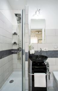La salle de bains blanche est pourvue d'un lavabo et d'une douche. dans l'établissement San Pietro Panoramic View, à Rome