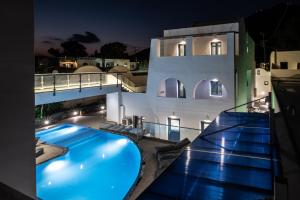 a villa with a swimming pool at night at Tristhenia in Perissa