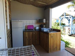 an outdoor kitchen with a sink and a refrigerator at Coeur Caraibes in Deshaies
