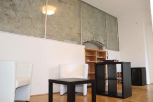 a room with a table and a chair and a shelf at Stifts-Suite in Klosterneuburg