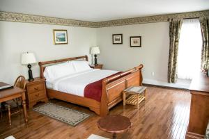 a bedroom with a bed and a desk and a window at The Harbour House in Charlottetown